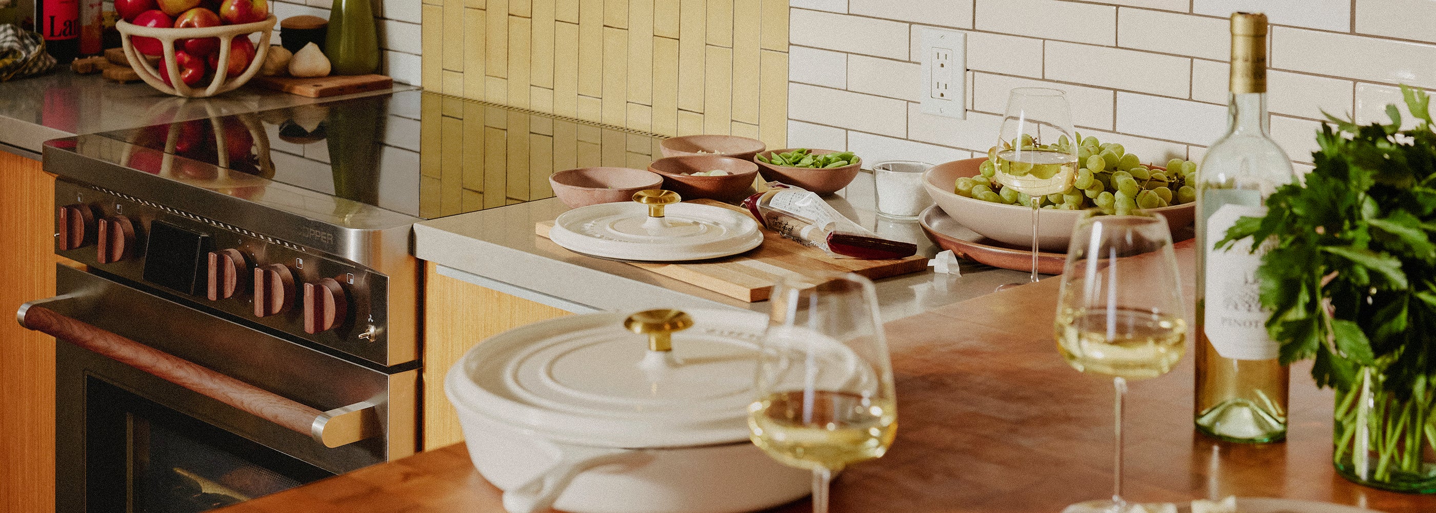 Kitchen counter with wine glasses, a pan, and food prepped waiting to be cooked on a Copper Charlie battery-powered induction stove compatible with 120v. 